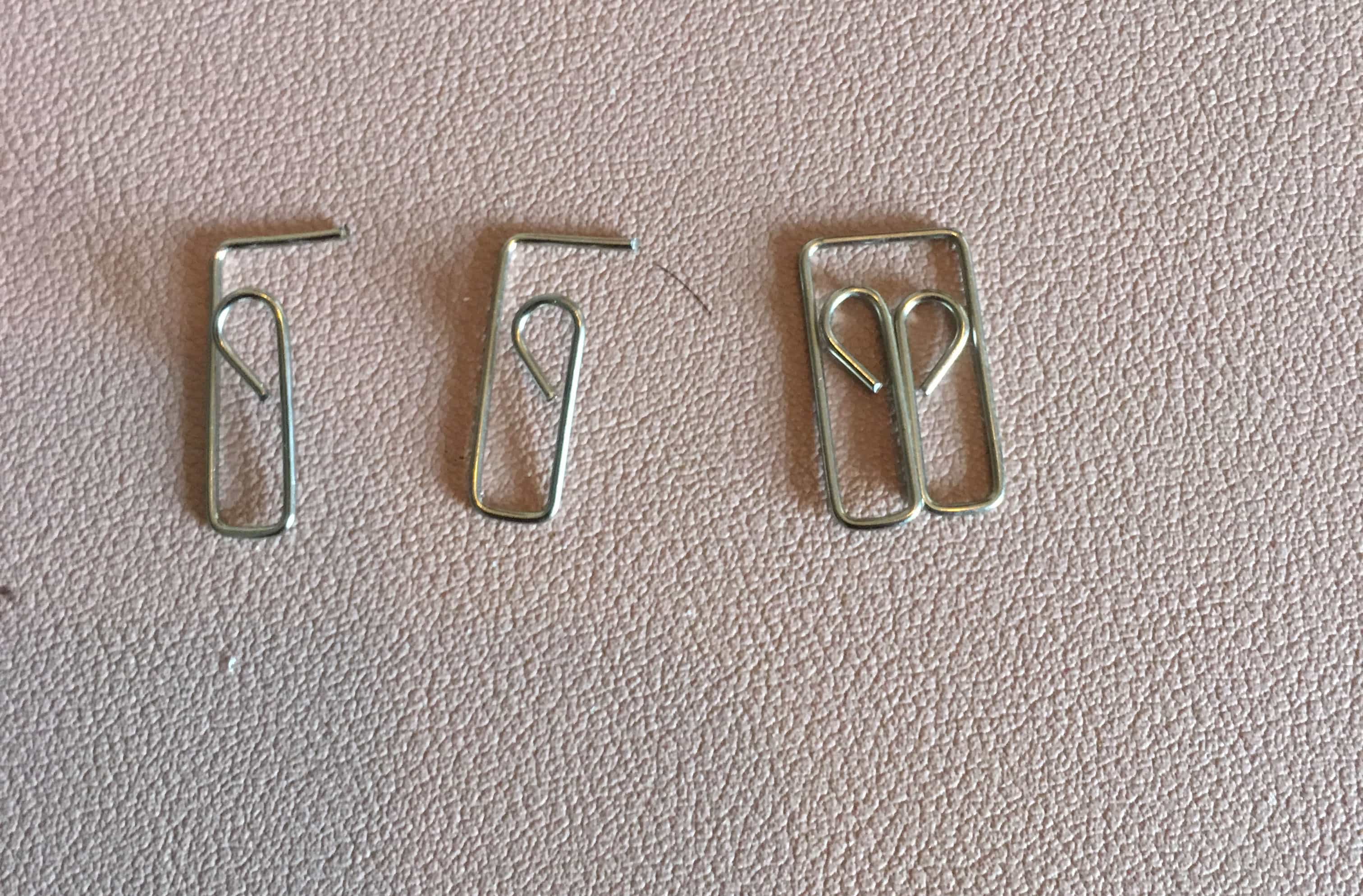 Two clipped paperclips and one that has not been cut.