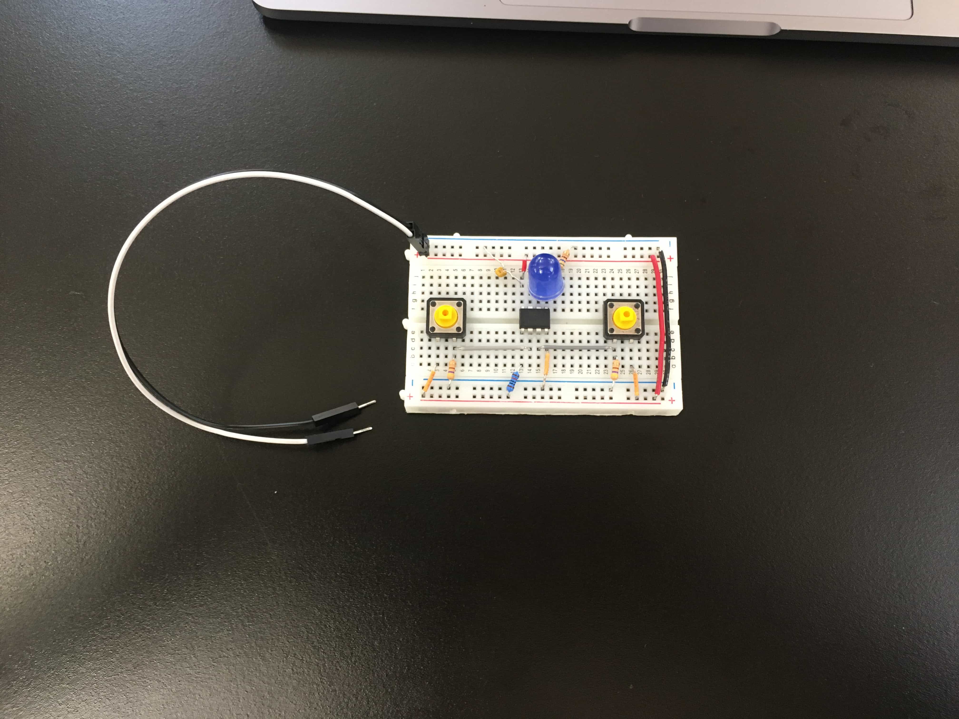 ATtiny85 on breadboard with LED and two push buttons.